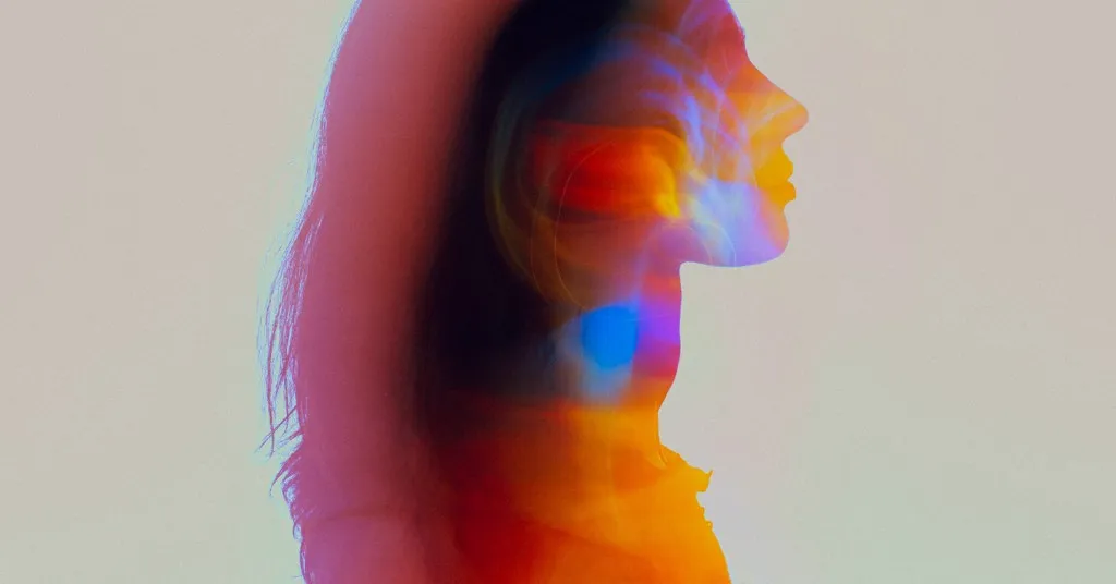 Profile of a person filled with pink, orange, and blue light